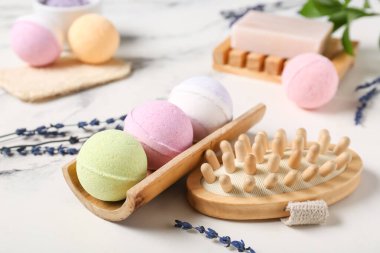 Masaj fırçalı banyo bombaları ve mermer arka planda lavanta çiçekleri, yakın plan.