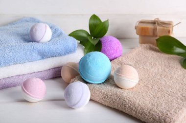 Havlulu banyo bombaları ve beyaz ahşap masa, yakın plan