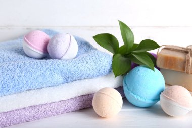 Havlulu banyo bombaları ve beyaz ahşap masa, yakın plan