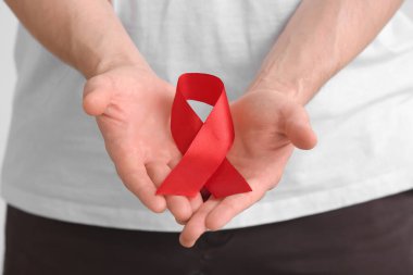 Beyaz arka planda kırmızı kurdeleli adam, yakın plan. Kan Kanseri Farkındalığı Ayı