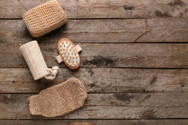 Masaj vücut fırçası, eldiven ve süngerle ahşap arka planda kompozisyon