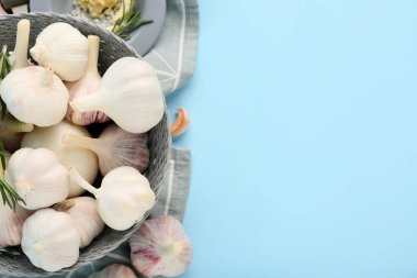 Taze sarımsaklı kase ve mavi arka planda biberiye.