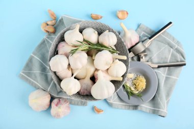 Taze sarımsaklı kase ve mavi arka planda biberiye.