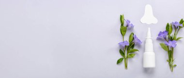 Kağıt burunlu bir şişe damla ve arka planda çiçekler. Mevsimsel alerji kavramı