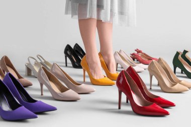 Kadın bacakları ve gri arka planda şık yüksek topuklar.