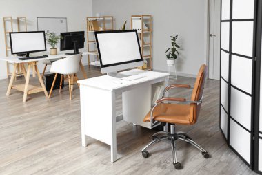 Modern işyerleri ve raf üniteleri olan hafif bir ofis.