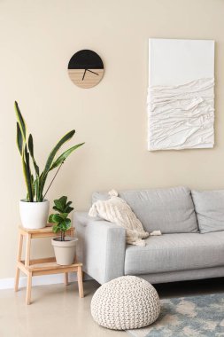 Rahat kanepesi, masası ve çiçeğiyle oturma odasının içinde.