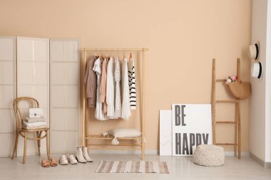 Elbise askılığı, sandalye ve katlama perdesi olan şık bir soyunma odası.