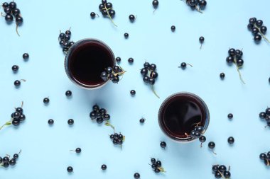 Mavi arka planda taze siyah frenk üzümü suyu ve böğürtlen