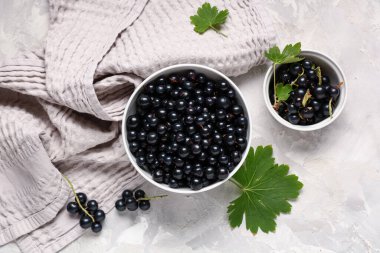 Gri arka planda taze siyah üzümlü kaseler