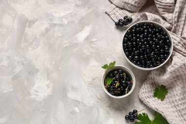 Gri arka planda taze siyah üzümlü kaseler