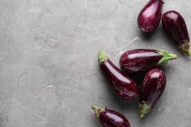 Gri arka planda bir sürü taze patlıcan