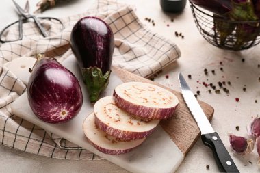 Beyaz arka planda taze patlıcanlar ve biberlerle kesilmiş tahta, yakın plan.