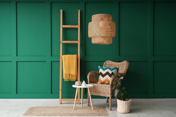 Interior of living room with wooden ladder, wicker armchair and table