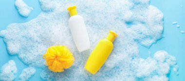 Renk arkaplanında köpüklü kozmetik ürünleri ve sünger.