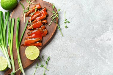 Domates soslu konserve balık, limon, soğan ve gri masada mikro yeşillikler.