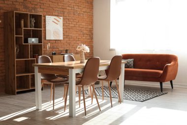 Oturma odası çatı katı tarzında, kanepe, masa ve sandalyeli.