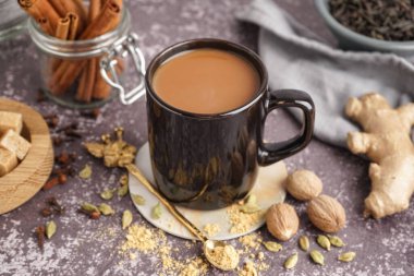 Bir fincan lezzetli masala çayı ve farklı baharatlar. Arka planda, yakın plan.