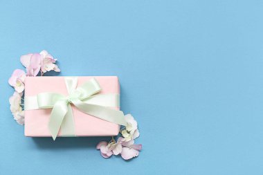 Mavi arka planda hediye kutusu ve ortanca çiçekleri. Uluslararası Kadınlar Günü