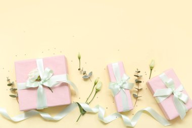 Güzel Eustoma çiçekleriyle hediye kutuları ve sarı arka planda okaliptüs. Uluslararası Kadınlar Günü