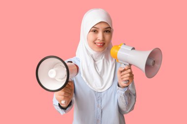 Pembe arka planda megafonları olan genç Asyalı Müslüman kadın. Ulusal Duyulma Günü