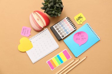 Planlar, not defterleri ve bej arka planda takvimler yapmak için yapışkan notlar. Yeni yıl hedefleri kavramı
