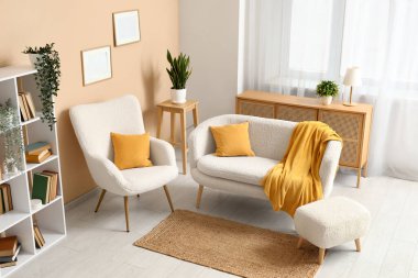 Rahat kanepesi, koltuğu, kitaplığı ve sarı ekoseli oturma odası.