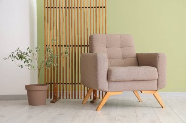 Yumuşak koltuklu, çiçekli ve katlanır perdeli güzel bir oturma odası.