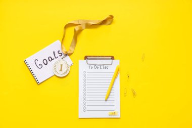 Madalya, yapılacaklar listesi ve sarı arkaplanda metin hedefleri olan not defteri