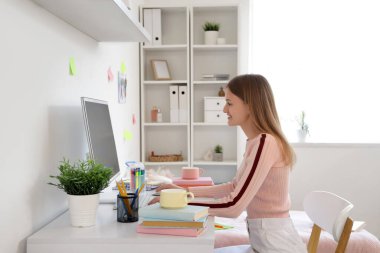 Yurt odasındaki masada bilgisayar kullanan bir kız öğrenci.