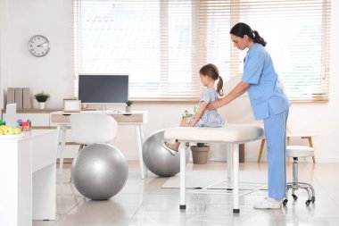 Klinikte küçük bir hastayla çalışan kadın osteopat.