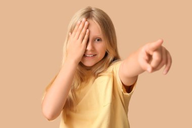 Genç bir kız bej arka planda görme yeteneğini kontrol ediyor. Çocuk Göz Sağlığı ve Güvenlik Bilinci Ayı