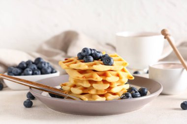 Masada beyaz arka planda yaban mersinli lezzetli Belçika waffleları