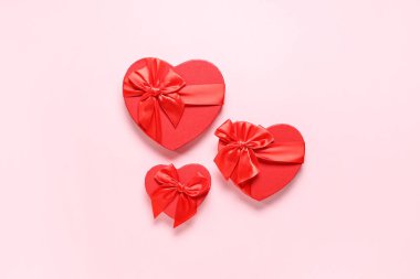 Pembe arka planda kalp şeklinde hediye kutuları. Sevgililer Günü kutlaması