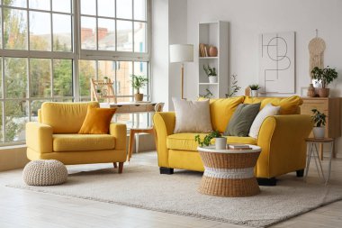 Rahat kanepesi, koltuğu ve sehpası olan bir oturma odası.