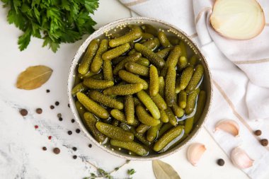 Lezzetli salatalıklı kase ve beyaz arka planda farklı baharatlar.