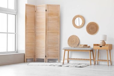 Yumuşak bank, ahşap masa ve katlanır ekran ile aydınlatma odasının içi