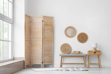 Yumuşak bank, ahşap masa ve katlanır ekran ile aydınlatma odasının içi