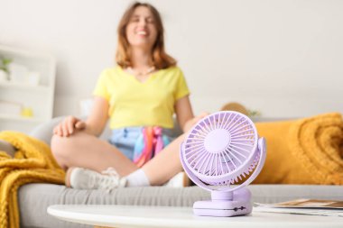 Mini fan masada oturan kadına karşı, yakın çekim.