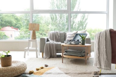 Oturma odasının içinde, masada ve koltukta pikap var.