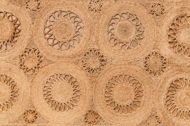 Oturma odasındaki kahverengi ahşap zeminde modaya uygun hasır halı dokusu.