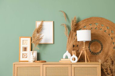 Çimenli vazolar, lamba ve fotoğraf çerçeveleri oturma odasındaki çekmecelerde, yakın plan.