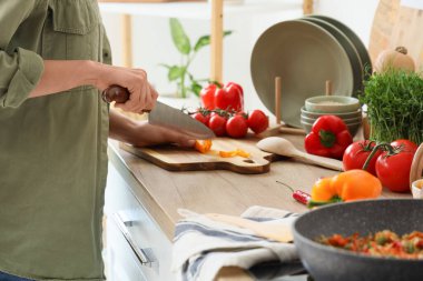 Mutfakta biber kesen genç bir kadın, yakın plan.