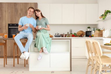 Mutfaktaki masada kahve içen genç bir çift.