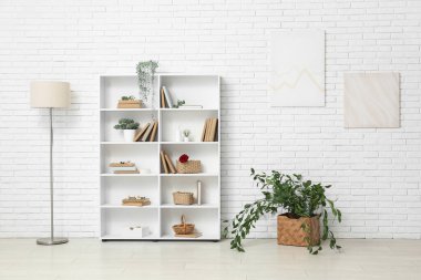 Kitaplığı, lambası ve bitkileri olan oturma odasının içinde.