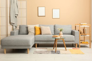 Kitaplığı, kanepesi ve masası olan bir oturma odası.