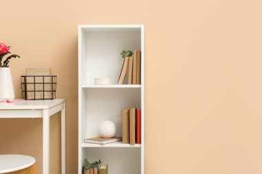 Odada bej duvarın yanında okaliptüs olan kitaplık.