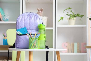 Sırt çantasında kurşun kalem bardağı ve su şişesi var.