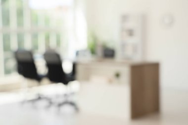 Masası, raf ünitesi ve palmiye bitkisi olan konferans salonunun içi.