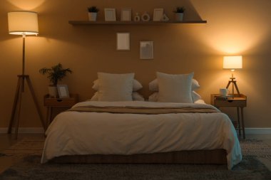 Geceleri karanlık odanın içinde yataklar, masalar ve parlayan lambalar.